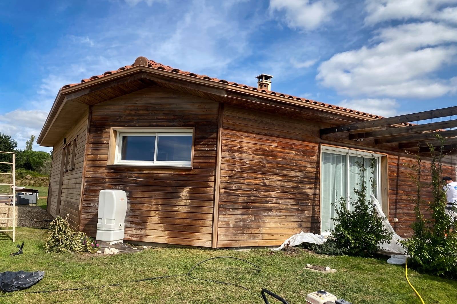 Pignon d’une maison à ossature bois, bardage grisé et bruni par les UV avant rénovation