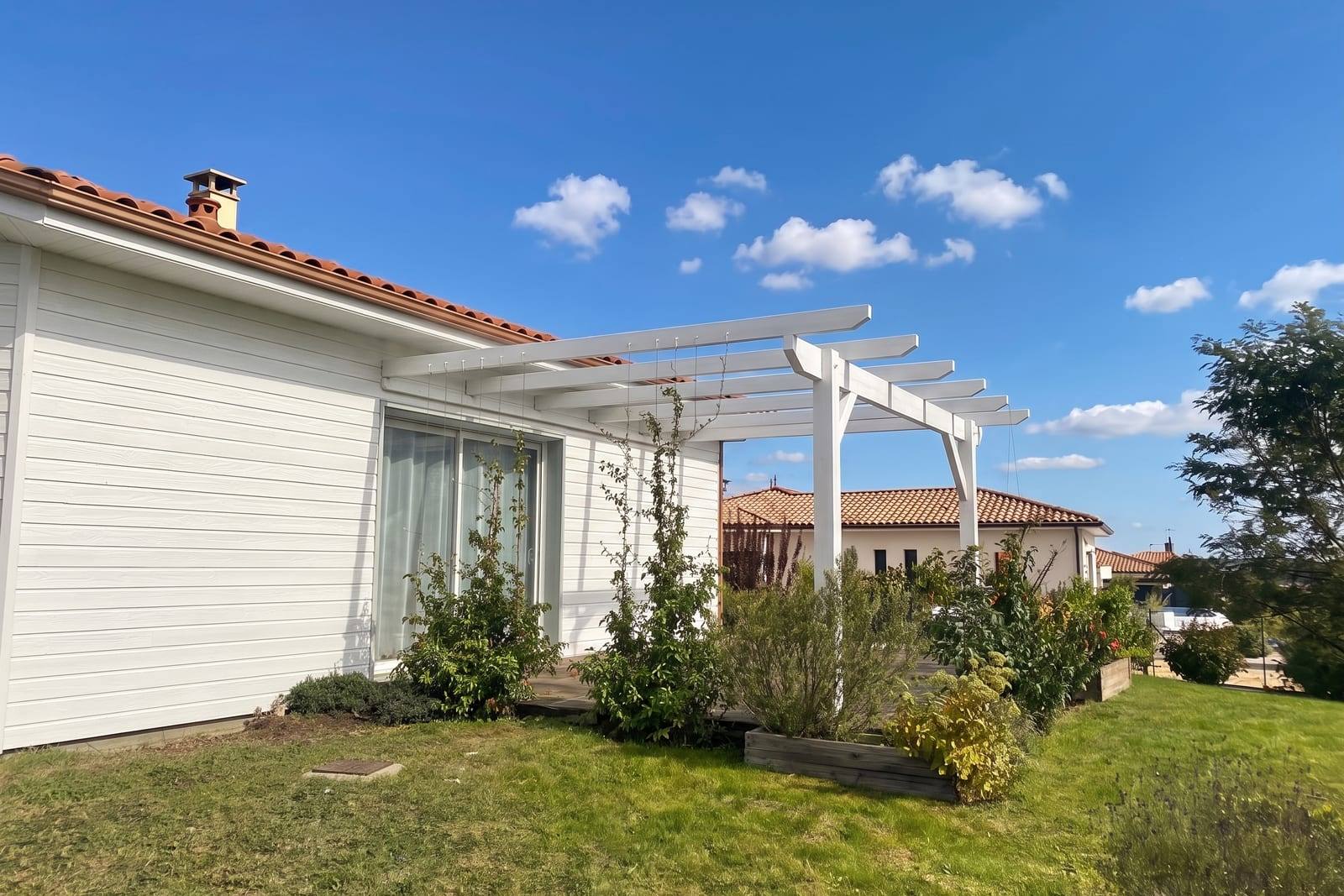 Façade et pergola repeintes en blanc cassé après rénovation du bardage bois, près de Marmande