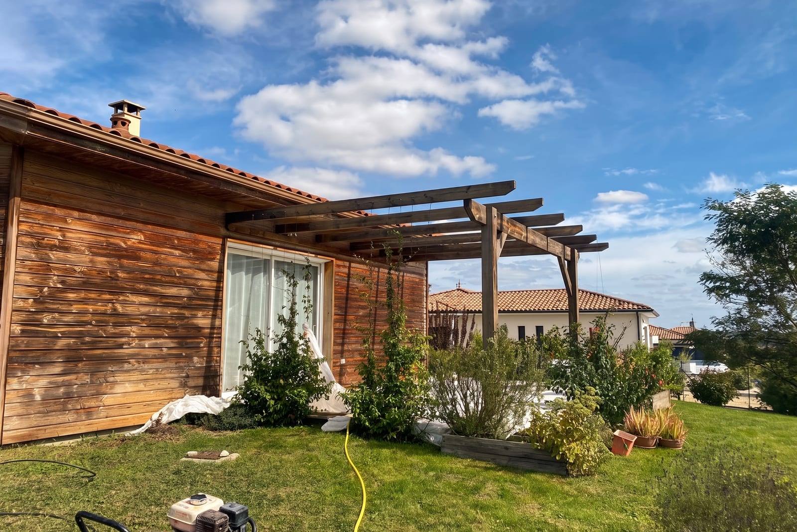 Façade en bardage bois et pergola grisés avant la rénovation, maison à ossature bois